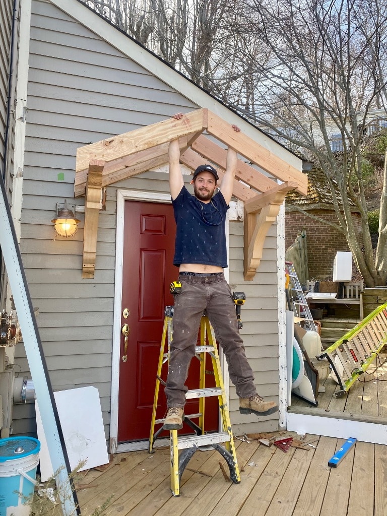 Murray Brothers crew member installing a custom cedar pergola over a home entry door