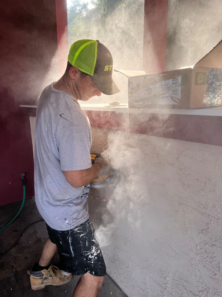 Murray Brothers crew member grinding and prepping a wall surface
